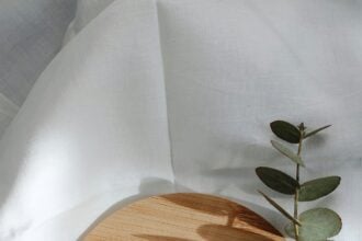 Organic skincare products arranged on marble with green botanical