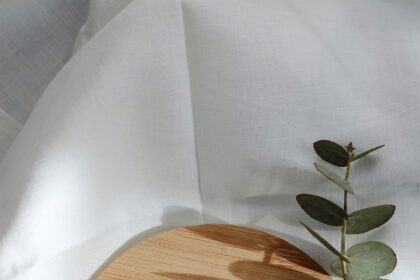 Organic skincare products arranged on marble with green botanical