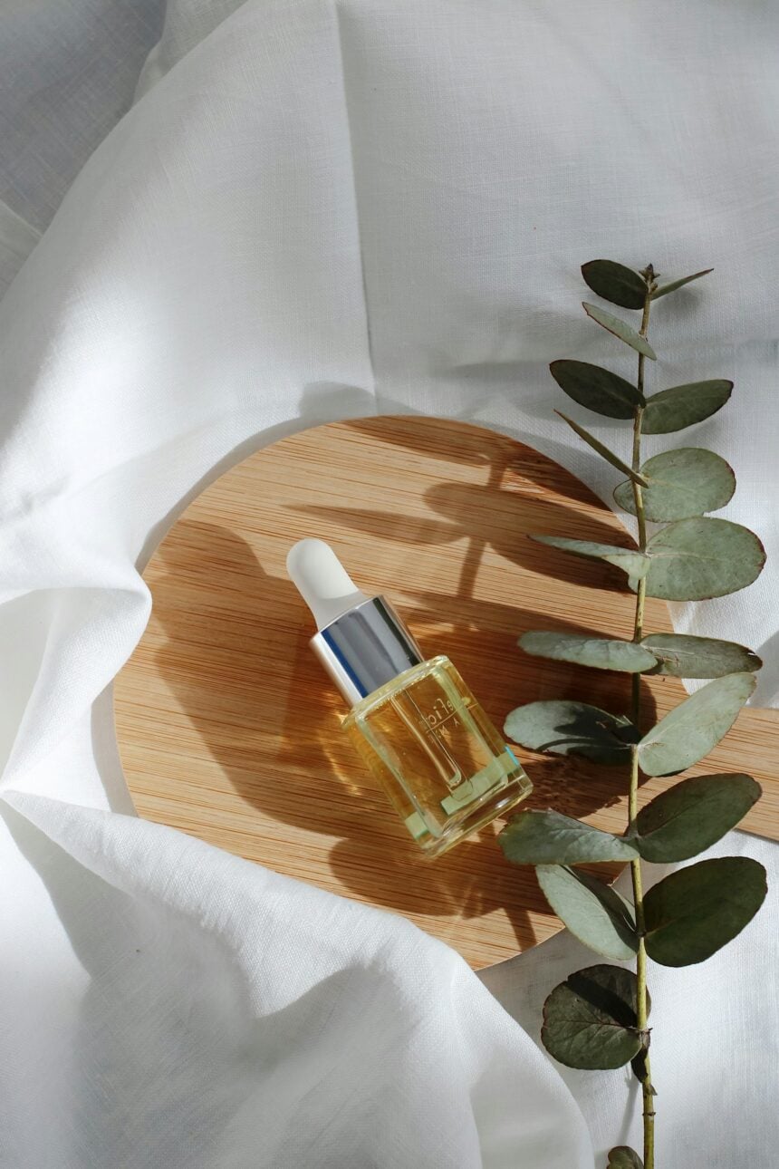 Organic skincare products arranged on marble with green botanical