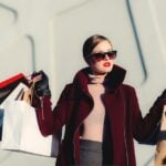 Woman browsing designer clothing racks in a bright boutique