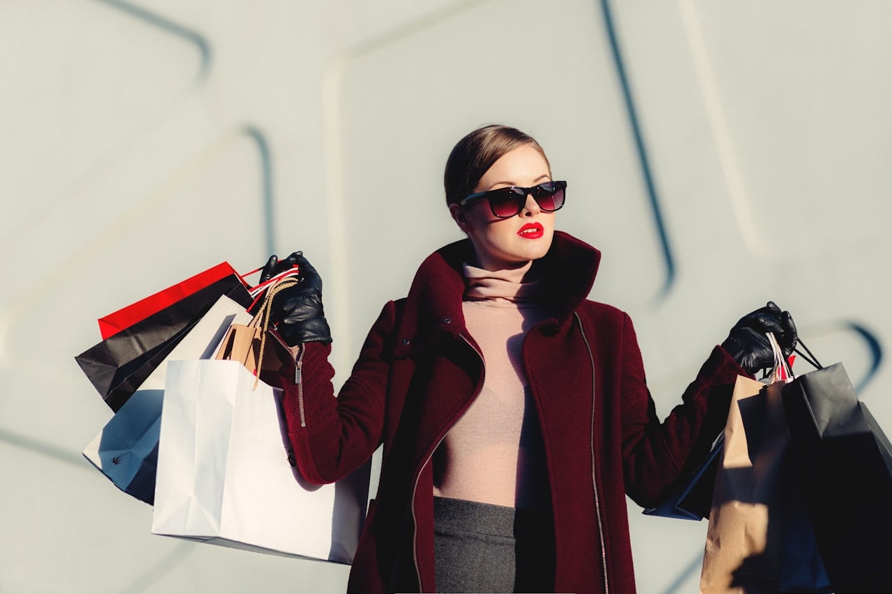 Woman browsing designer clothing racks in a bright boutique