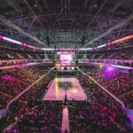 Colorful NBA arena crowd cheering courtside at night