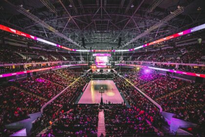Colorful NBA arena crowd cheering courtside at night