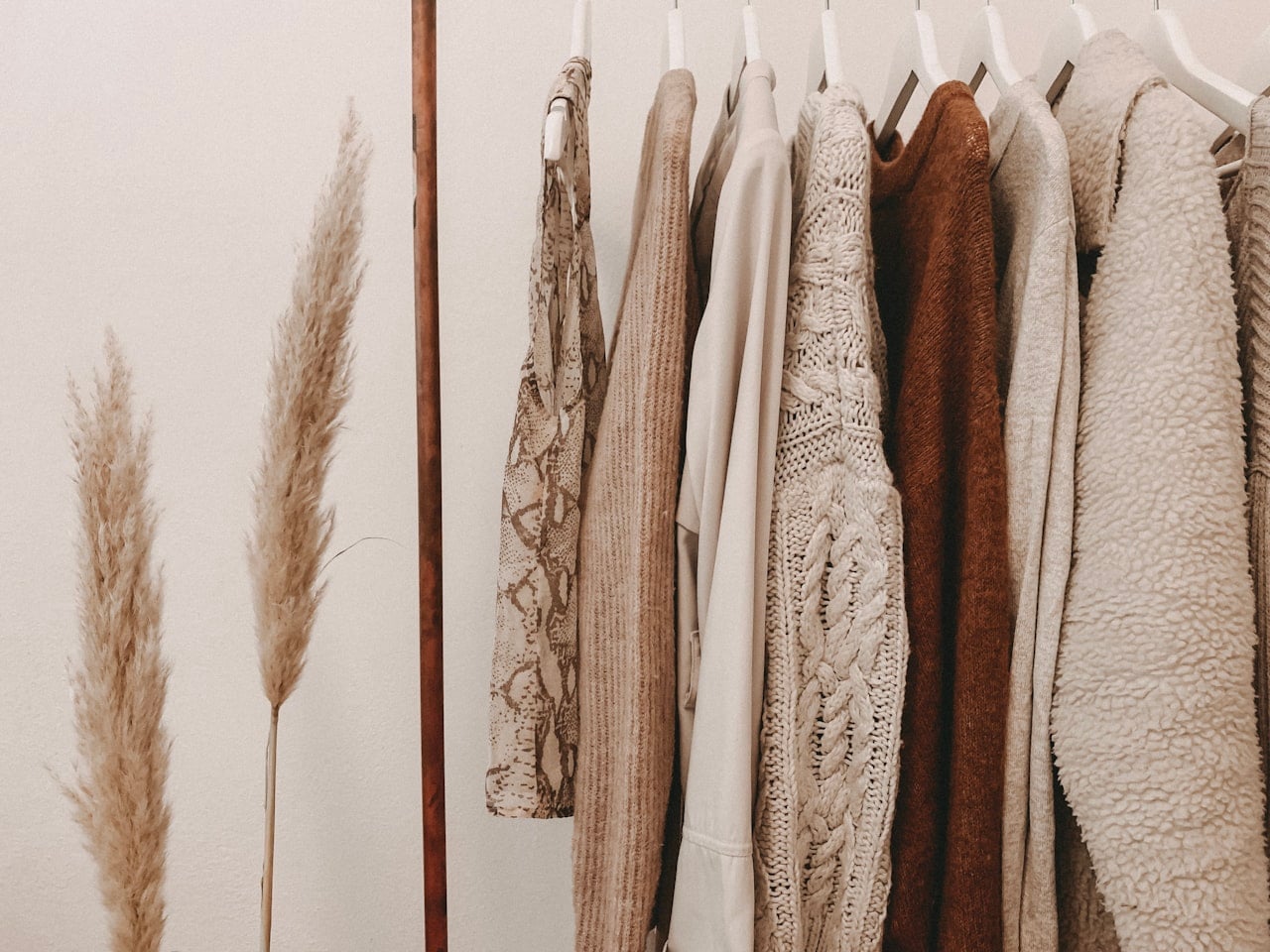 Minimal capsule wardrobe with neutral tones on open rack