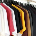 Rack of colorful vintage clothing hanging in a shop