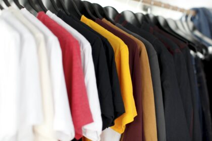 Rack of colorful vintage clothing hanging in a shop