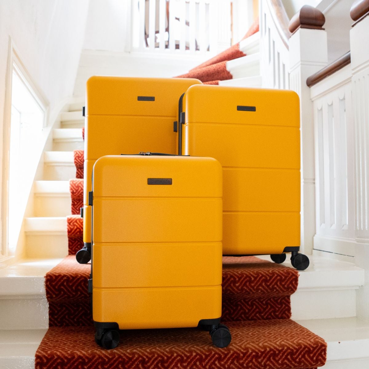 Yellow Journeylife suitcase set on stairs