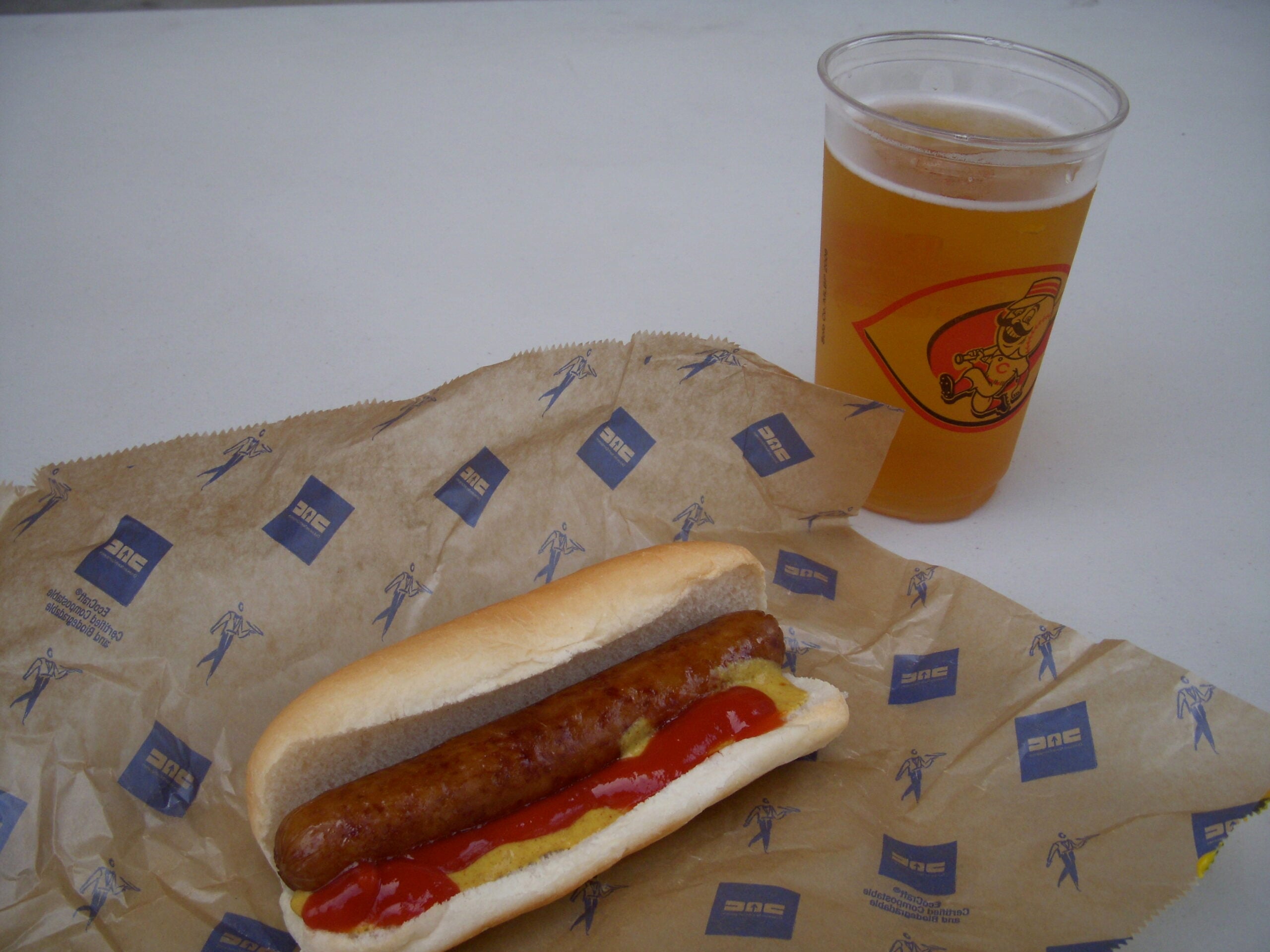 A classic ballpark hot dog and a cup of beer at a baseball game