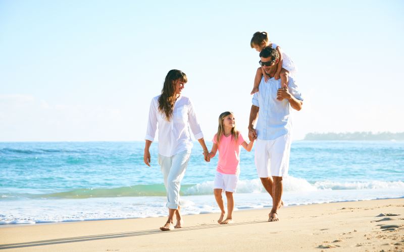 Famiglia che cammina su una spiaggia durante una vacanza