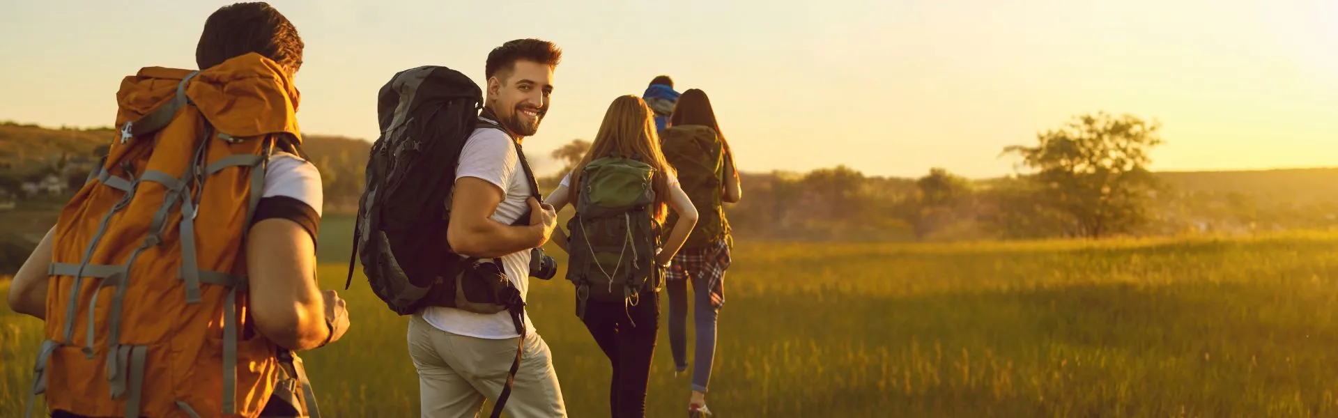 Senderistas caminando por un campo al atardecer