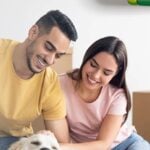 Coppia con cane e scatole in un ambiente domestico