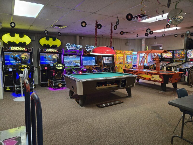 An arcade room with a pool table at a Host location