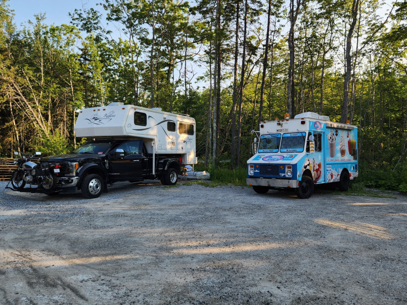 A truck camper beside a food truck at a Host location