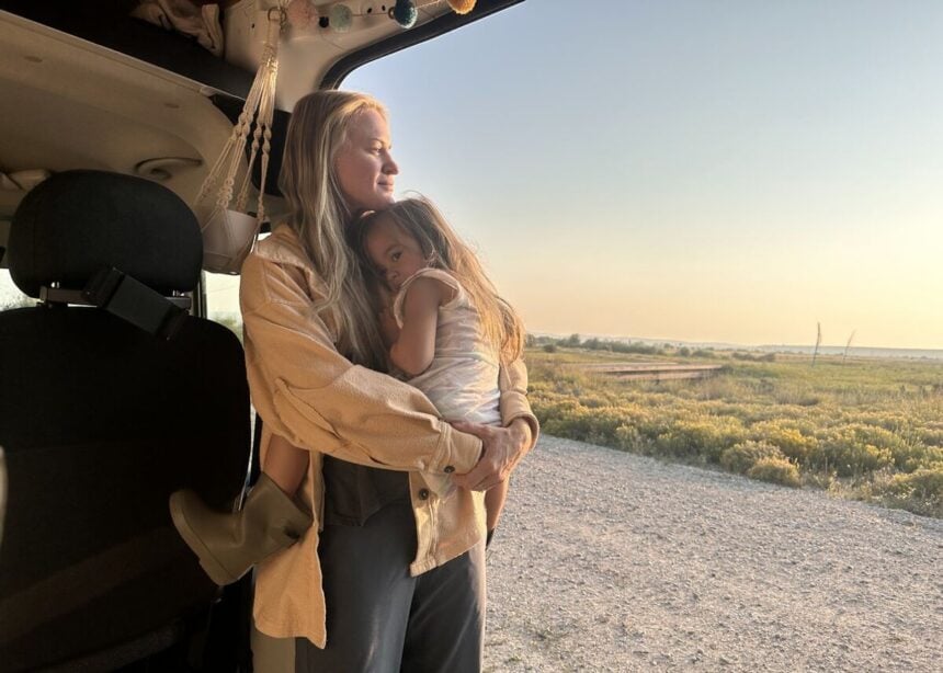 Woman and child beside an RV in the early morning