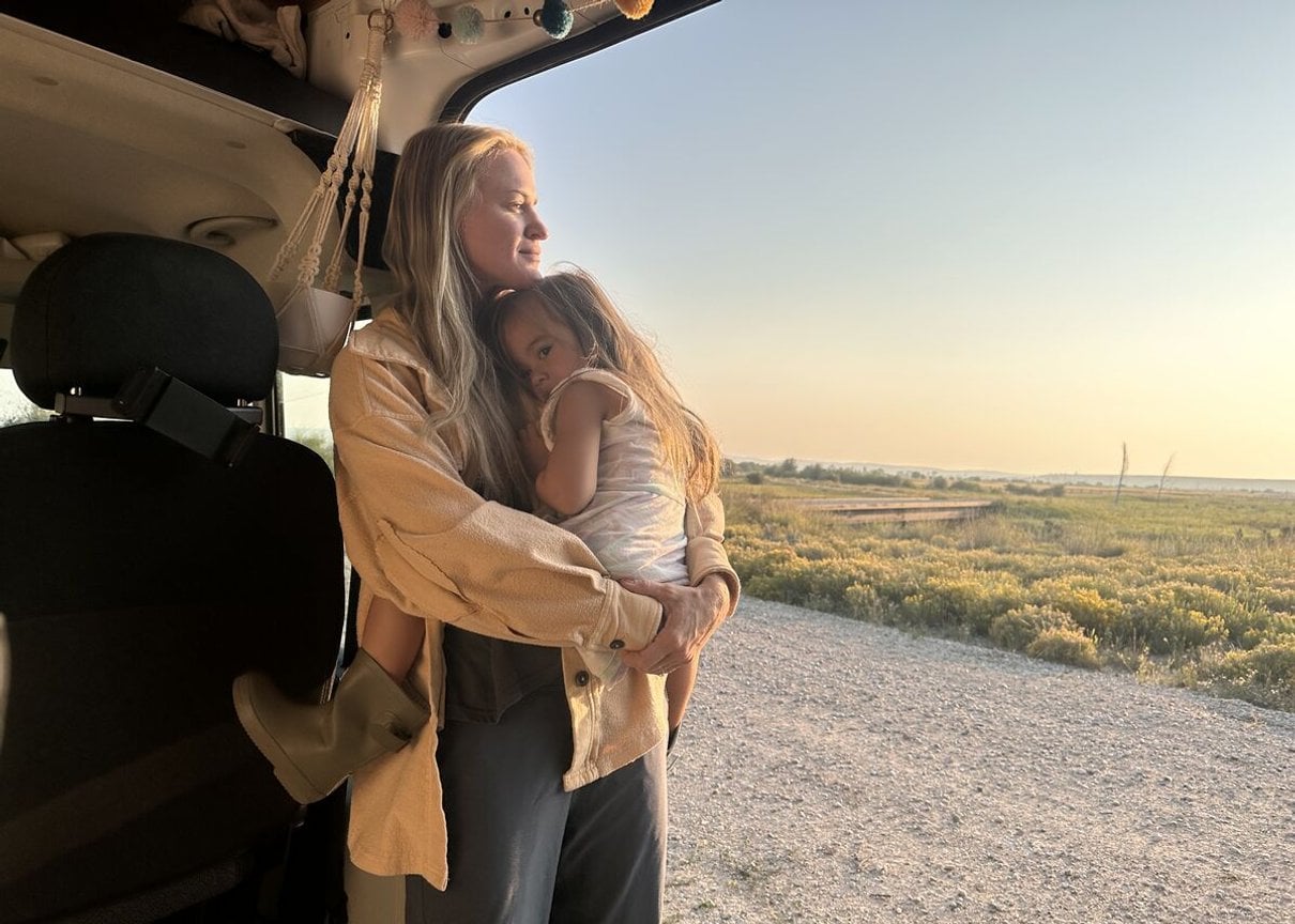 Woman and child beside an RV in the early morning