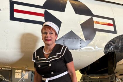 Woman standing beside a historic warbird fuselage