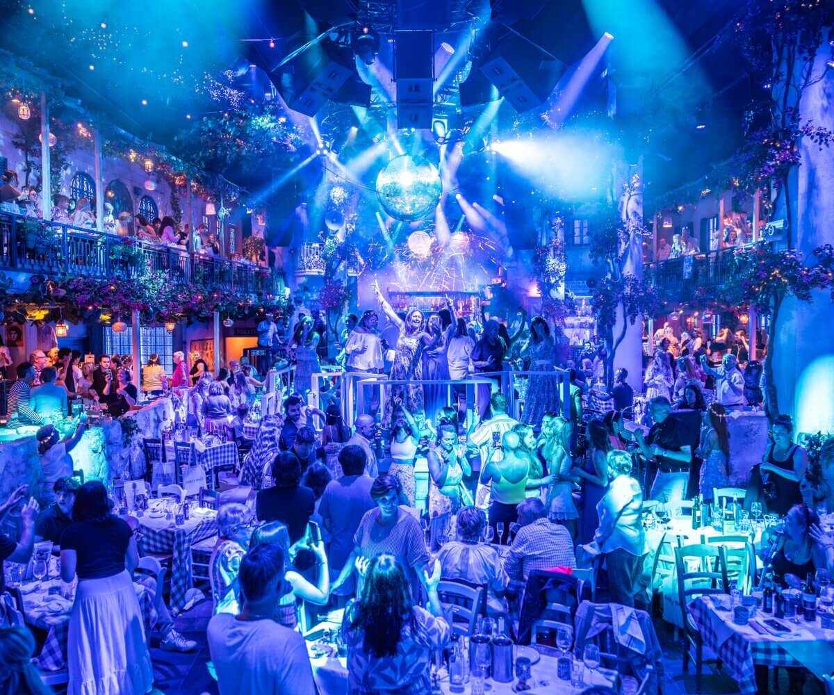 Crowd dancing under the disco ball during the ABBA disco at Mamma Mia! The Party