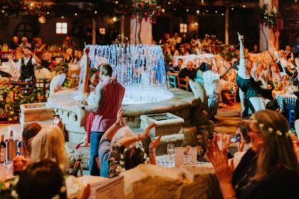 Couple dancing by the illuminated fountain as the crowd cheers at Mamma Mia! The Party