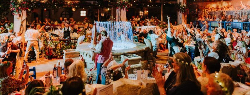 Couple dancing by the illuminated fountain as the crowd cheers at Mamma Mia! The Party