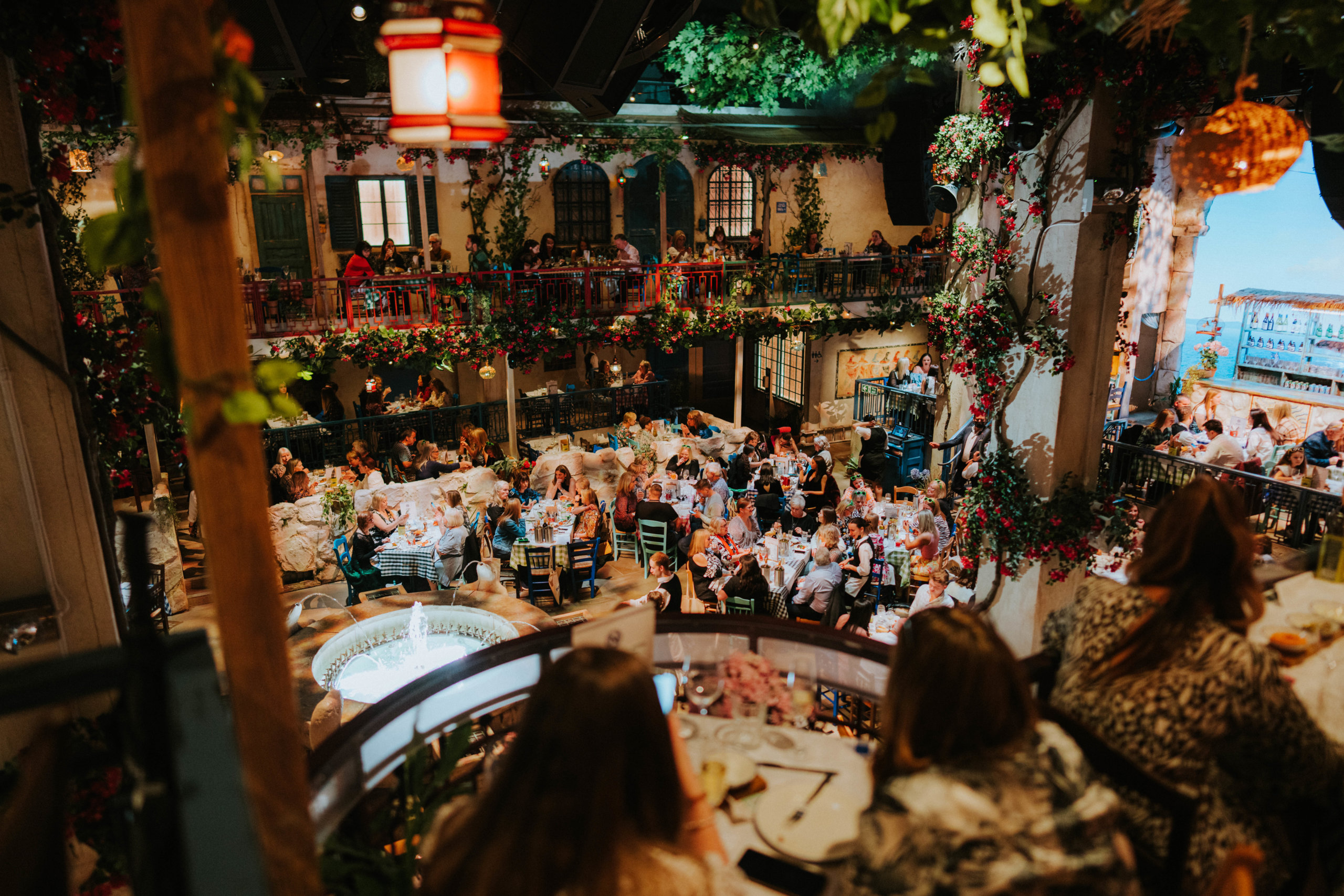 Elevated view of Nikos taverna set with ivy, red lanterns and diners at Mamma Mia! The Party