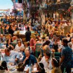 Packed Nikos taverna set with guests in flower crowns at Mamma Mia! The Party