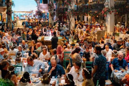 Packed Nikos taverna set with guests in flower crowns at Mamma Mia! The Party