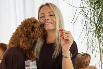 Femme assise avec un chien et un flacon KSM-66 Ashwagandha Nature’s Finest