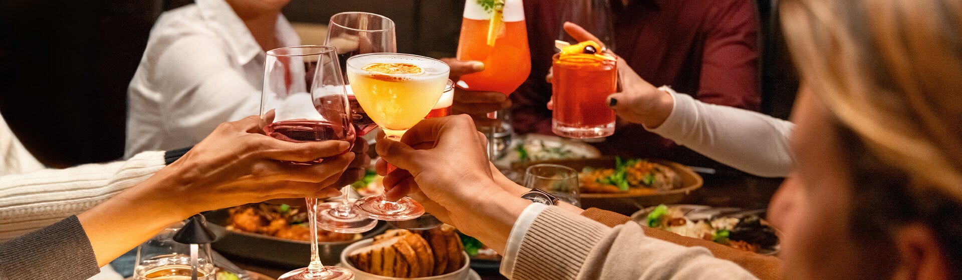 Diners toasting cocktails at ONE Dine