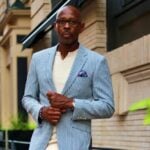 Man wearing a light blue pinstripe summer suit outdoors