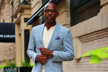 Man wearing a light blue pinstripe summer suit outdoors