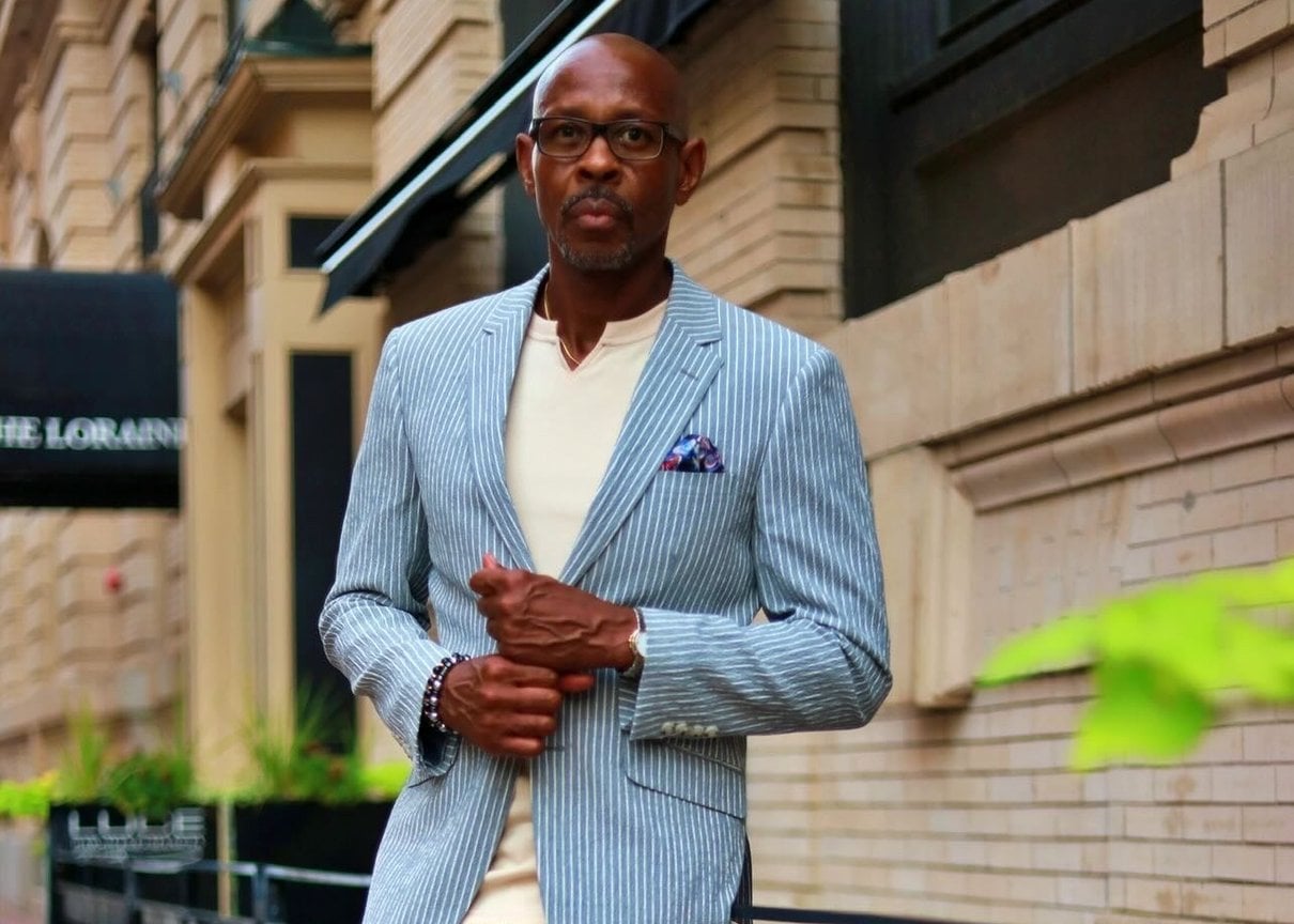 Man wearing a light blue pinstripe summer suit outdoors