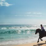 Traveller riding a horse on a beach holiday
