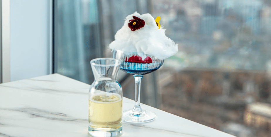 Champagne and a decorative cocktail beside a window