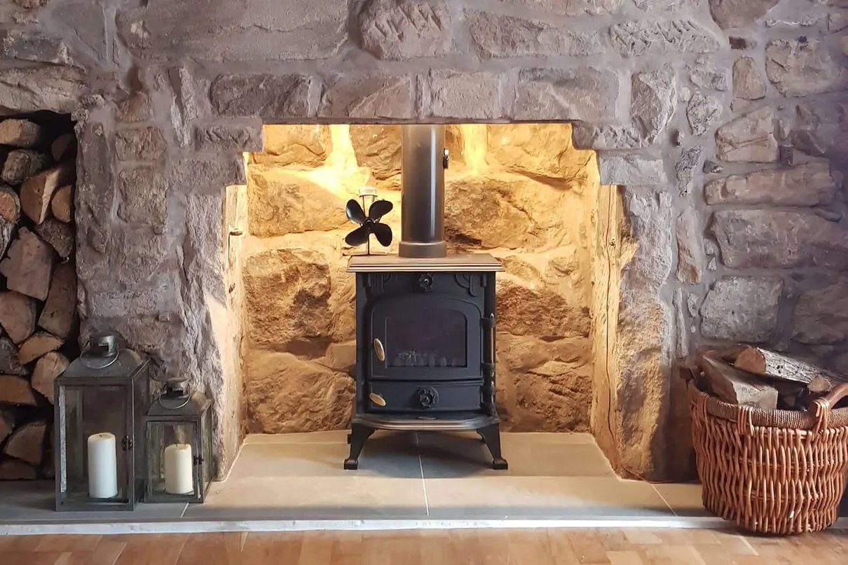 Wood stove in a fireplace with warm accent lighting