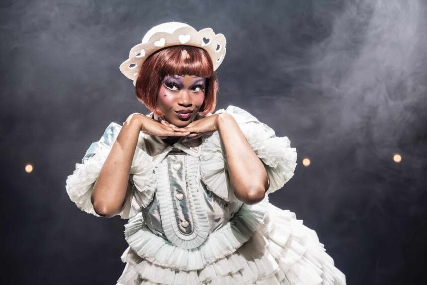 Cabaret performer posing in a white costume on stage