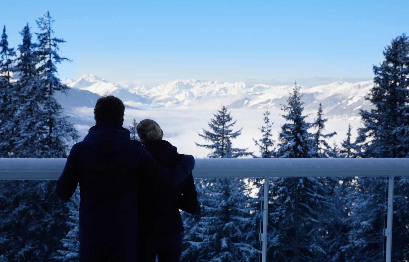 Couple looking across snowy mountains at a Club Med resort