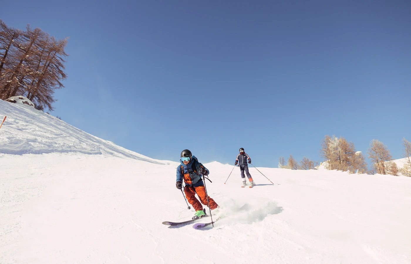 Skiers descending a snowy slope at a Club Med resort