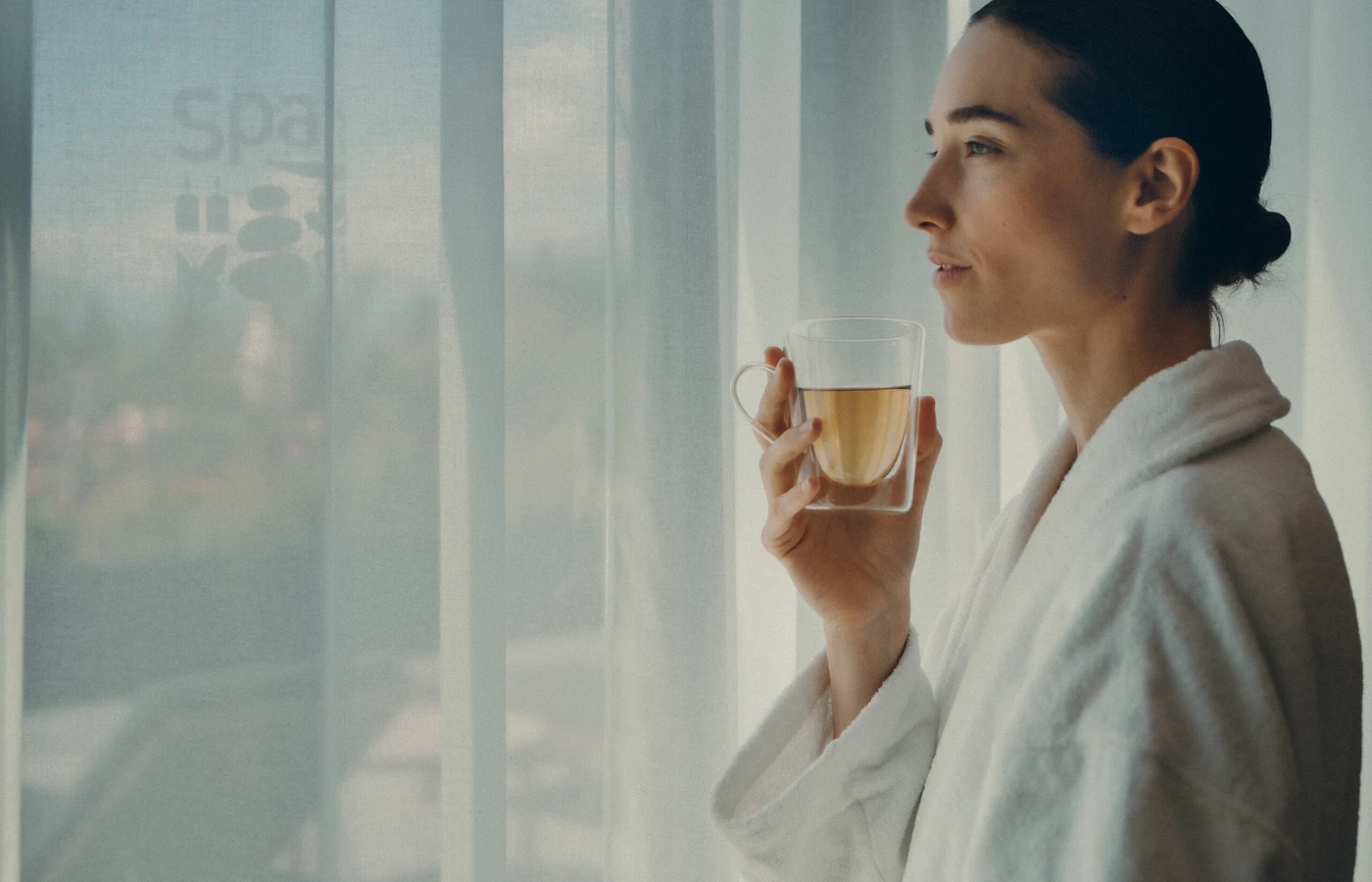 Woman drinking tea beside a resort window