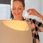 Donna che cambia una lampadina in casa