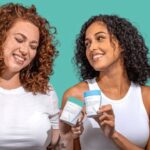 Two women holding Happy V wellness products