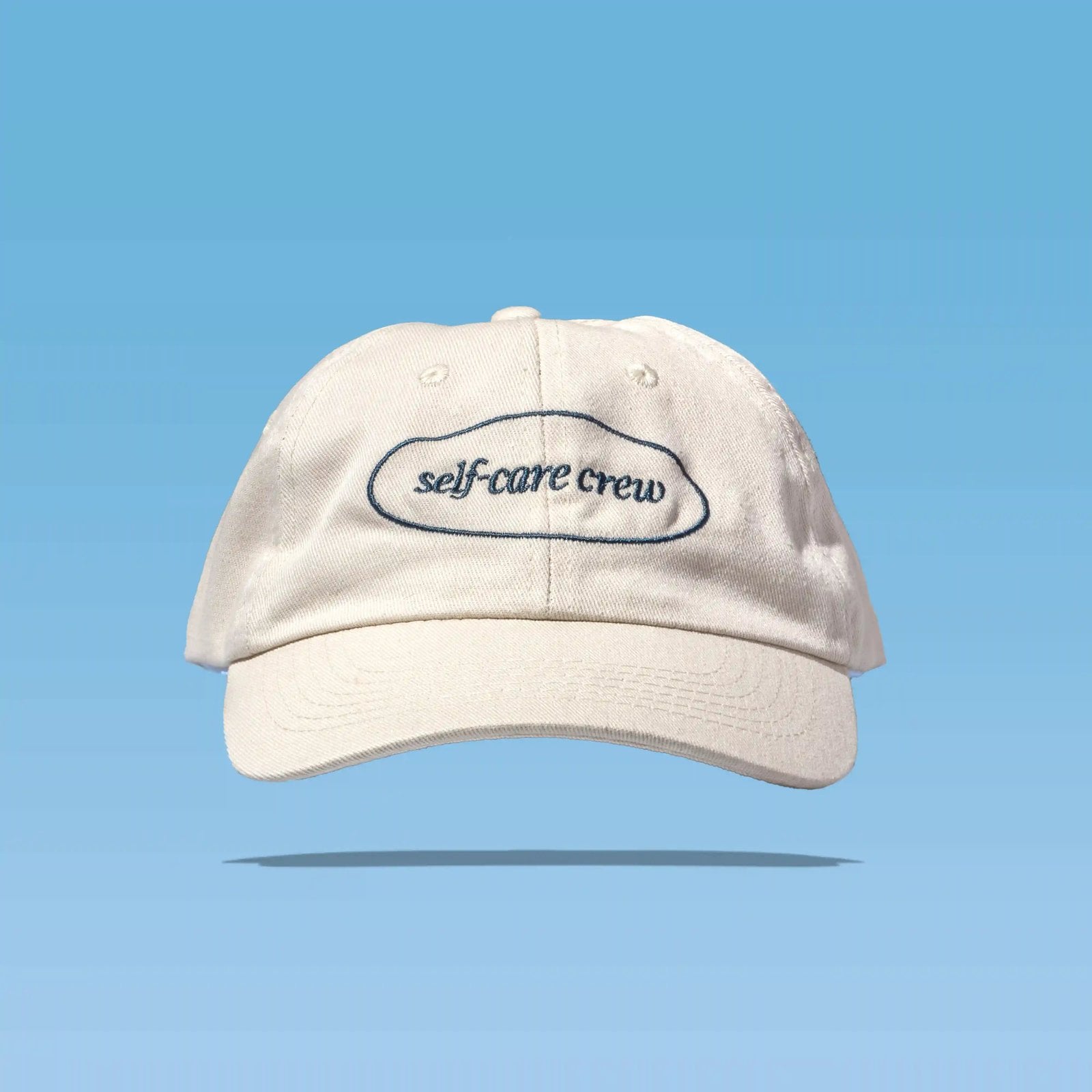 Happy V Self-Care Crew Hat on a blue background