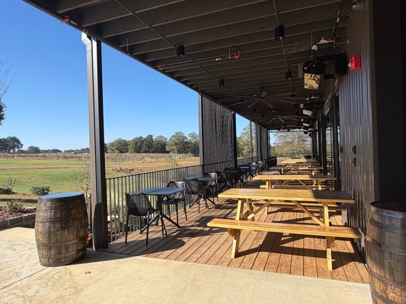 Winery patio with a vineyard beyond it