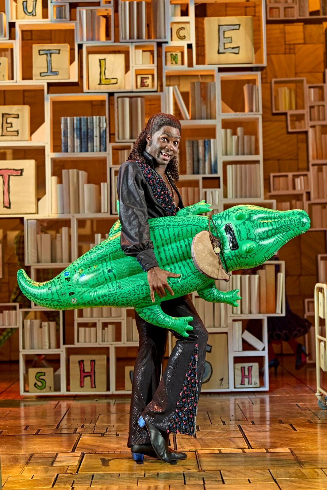 Matilda The Musical performer with an inflatable crocodile on stage