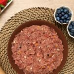 Cuenco con comida natural cruda y trozos de fruta