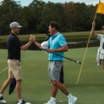 Golfers shaking hands on a green