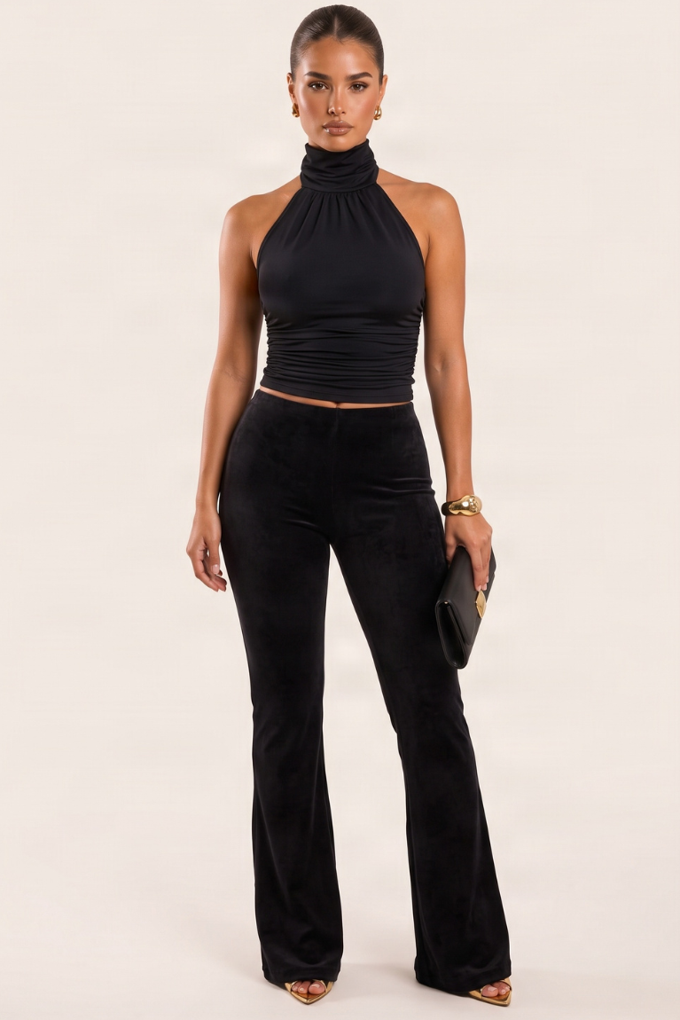 Black velvet kick flare trousers on a model