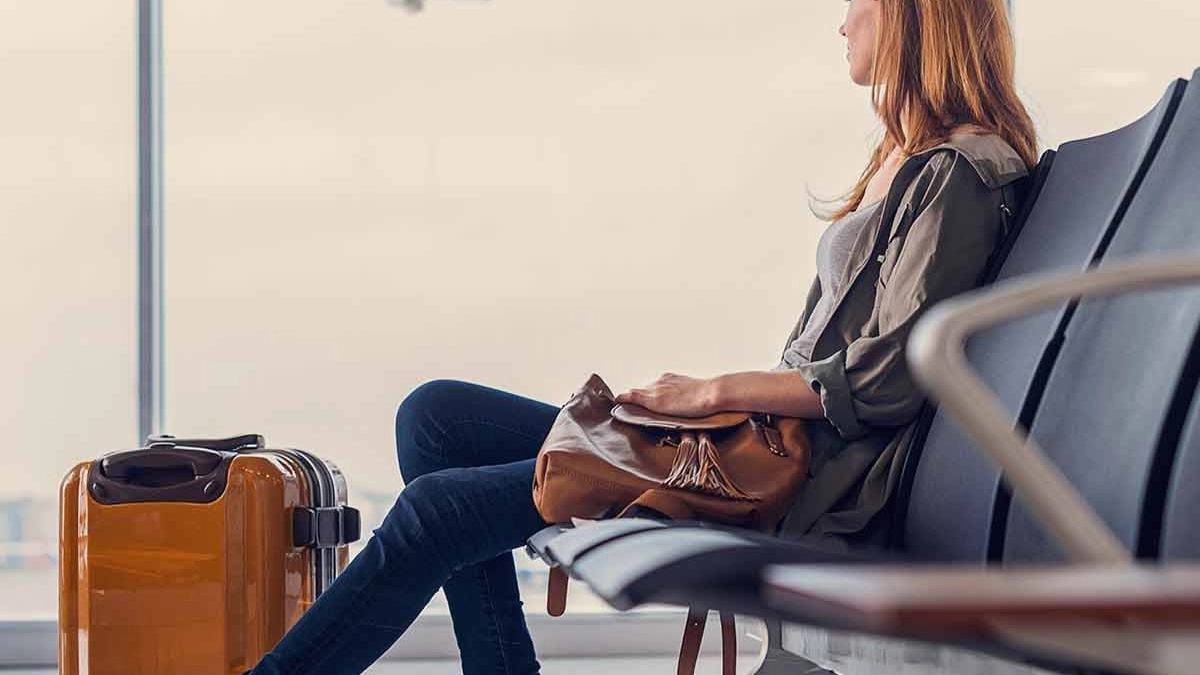 Woman sitting in an airport with her luggage