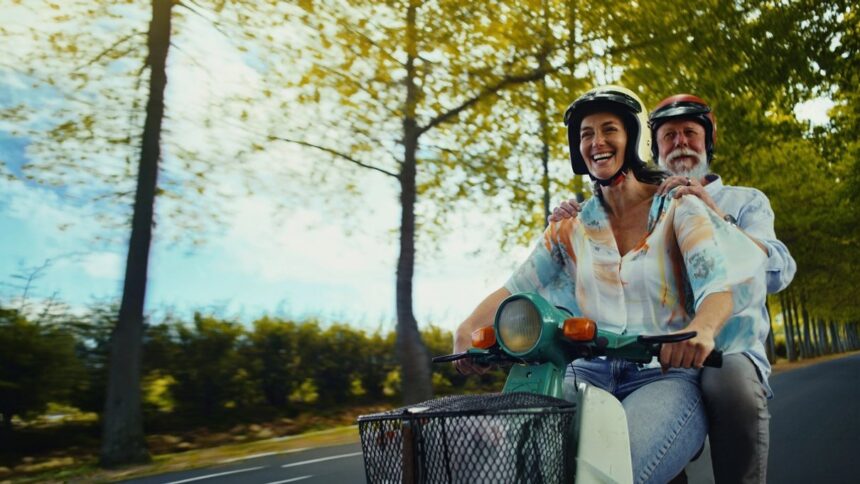 Traveller riding a moped on holiday, representing Staysure travel insurance