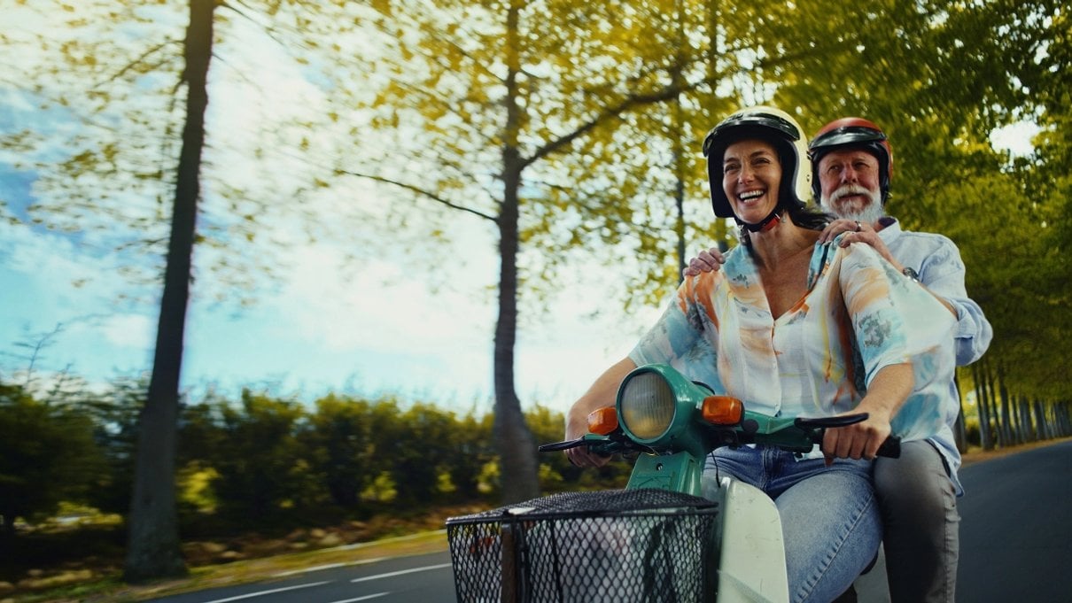 Traveller riding a moped on holiday, representing Staysure travel insurance