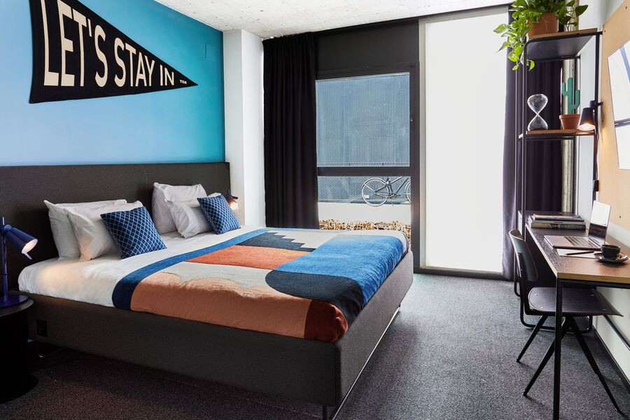 Habitación contemporánea de hotel en Madrid con cama doble y escritorio